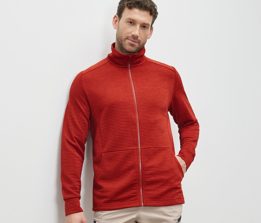 Mann trägt rote Funktionsjacke.