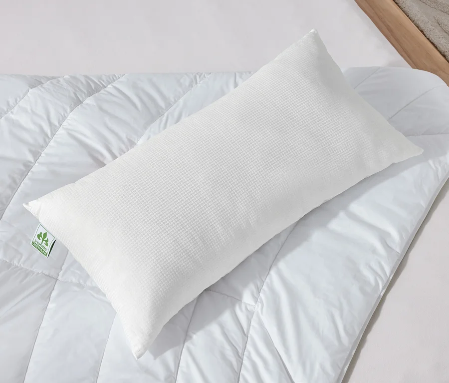 Zwei weiße irisette® greenline Kopfkissen mit Outlast®-Technologie liegen auf einer weißen Bettdecke.