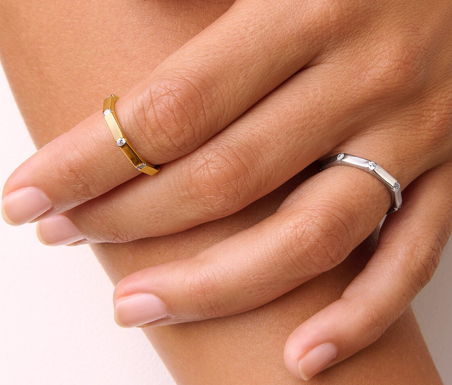 Detailaufnahme einer Damenhand, die einen goldenen 925 Silber Ring Octagon und einen 925 Silber Ring Octagon trägt.