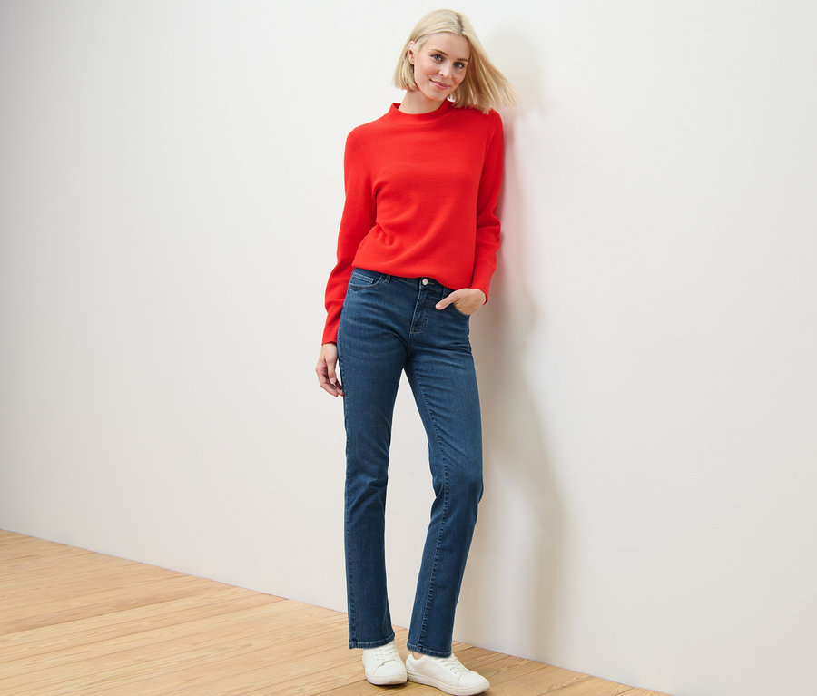 Blonde Frau posiert in rotem Pullover und Straight Jeans – Fit »Kira«.