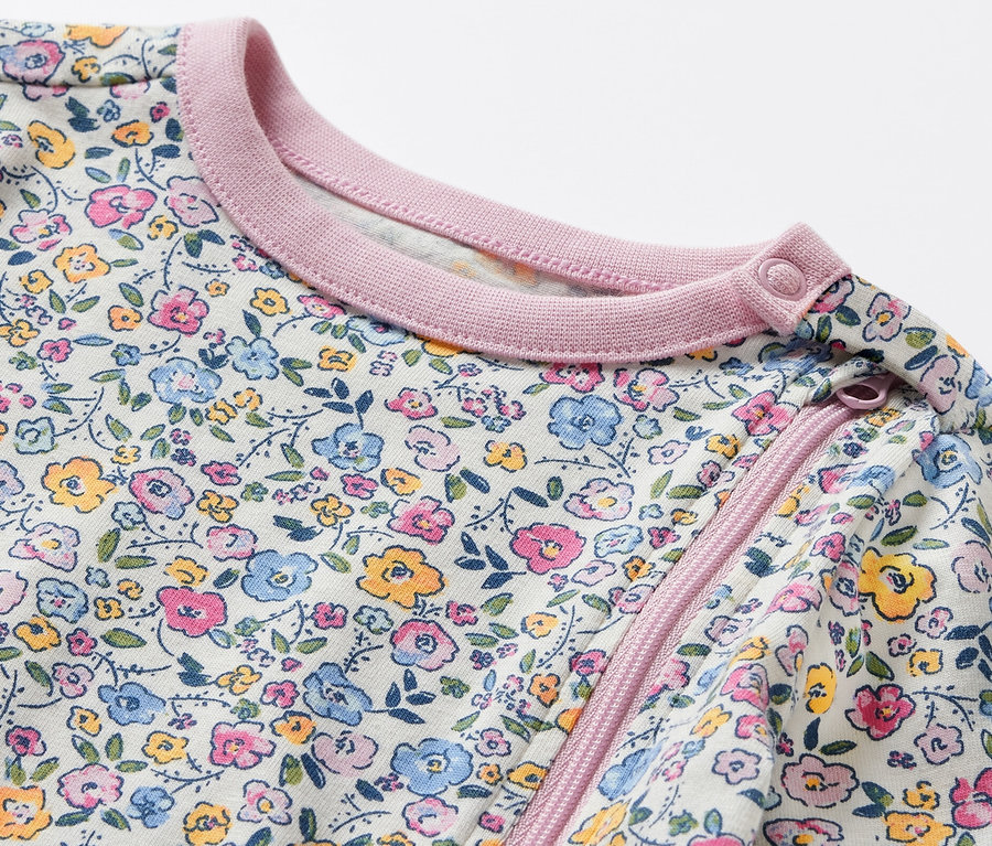 Detailansicht eines Baby-Pyjamas mit Blumenmuster.