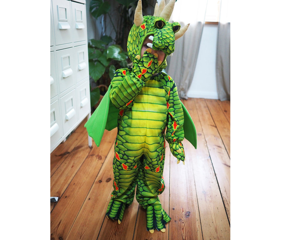 Kind im grünen small foot Kostüm »Drache«.