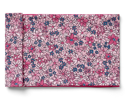 Ein gefaltetes Stoffserviette mit Blumenmuster in Rosa, Weiß und Blau.