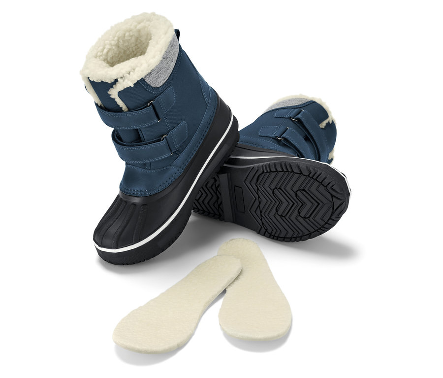 Zwei blaue Schneestiefel mit schwarzen Sohlen und Fellfutter und zwei Fellfußbetten.