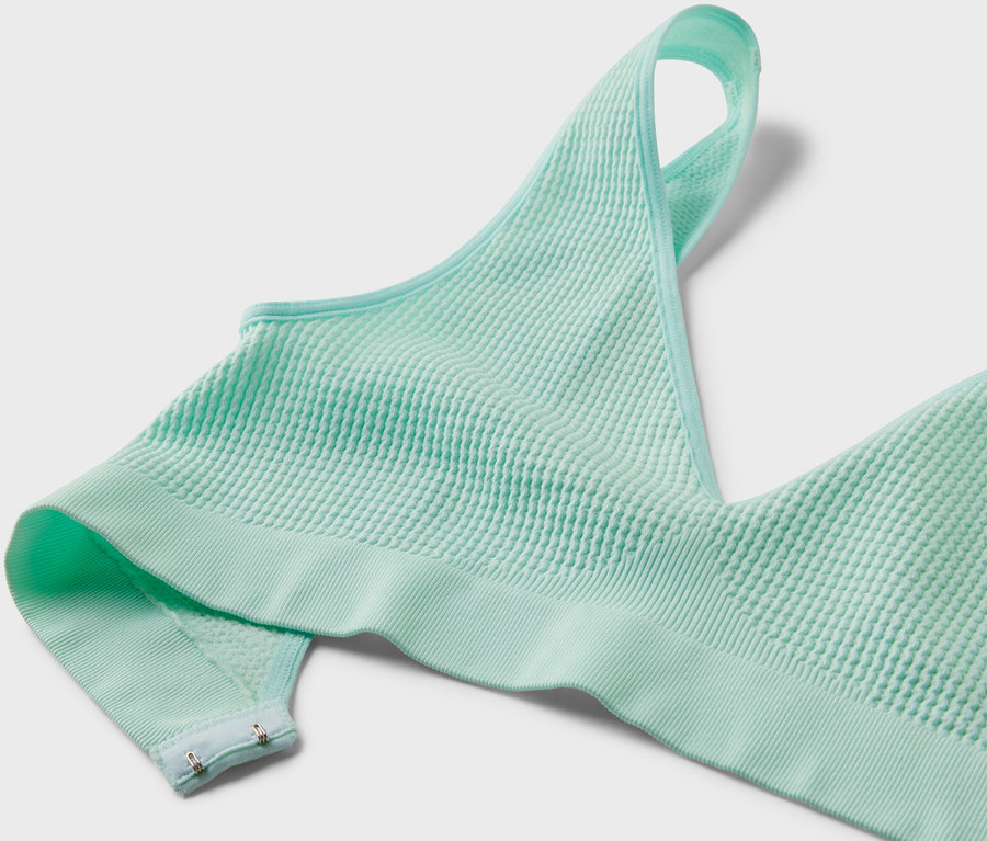 Detailansicht eines helltürkisen Seamless-BH mit Struktur.