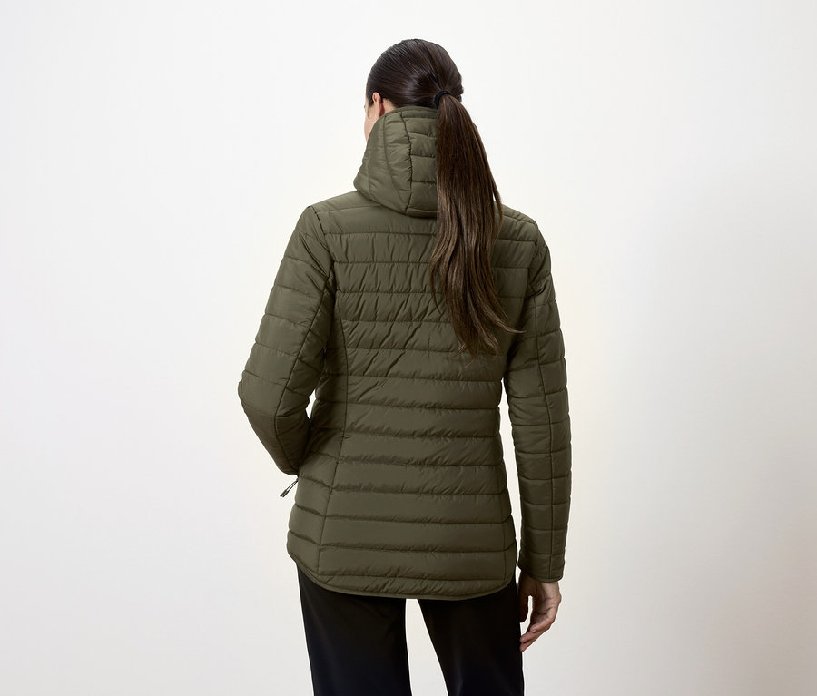 Rückansicht einer Frau in olivgrüner Steppjacke und schwarzer Hose.