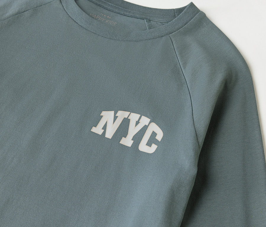 Detailansicht eines 2er-Kinderpyjama-Sets mit NYC-Aufdruck auf dem T-Shirt.