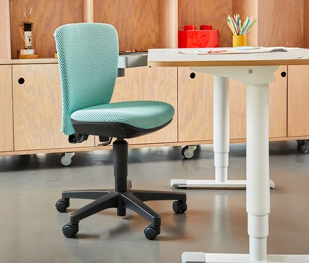 Mintgrüner Topstar Sitness »Home S'cool« Bürostuhl vor hellem Holzschrank und Schreibtisch.
