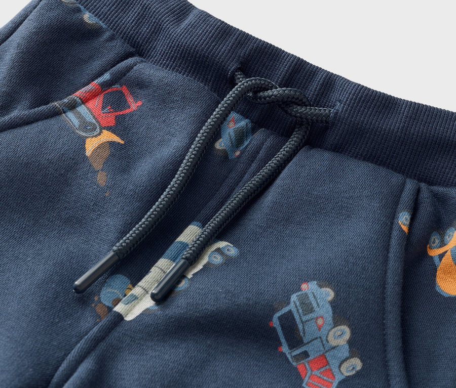 Nahaufnahme von marineblauen Jogginghosen mit Kordelzug und Bauarbeiter-Motiv.
