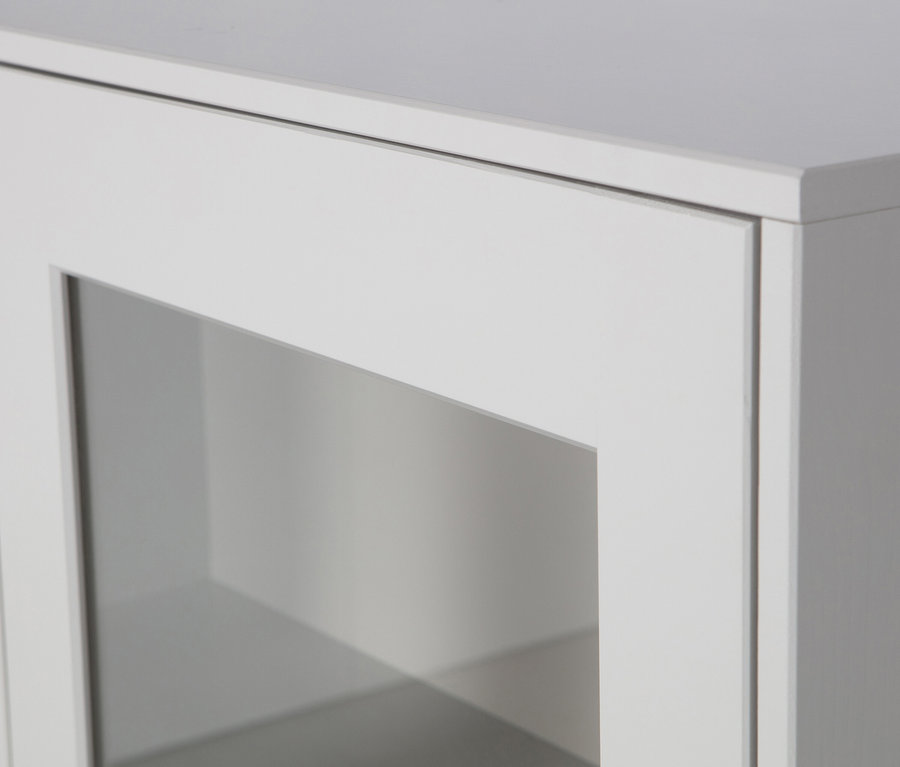 Detailansicht eines weißen Schranks mit Glastür.