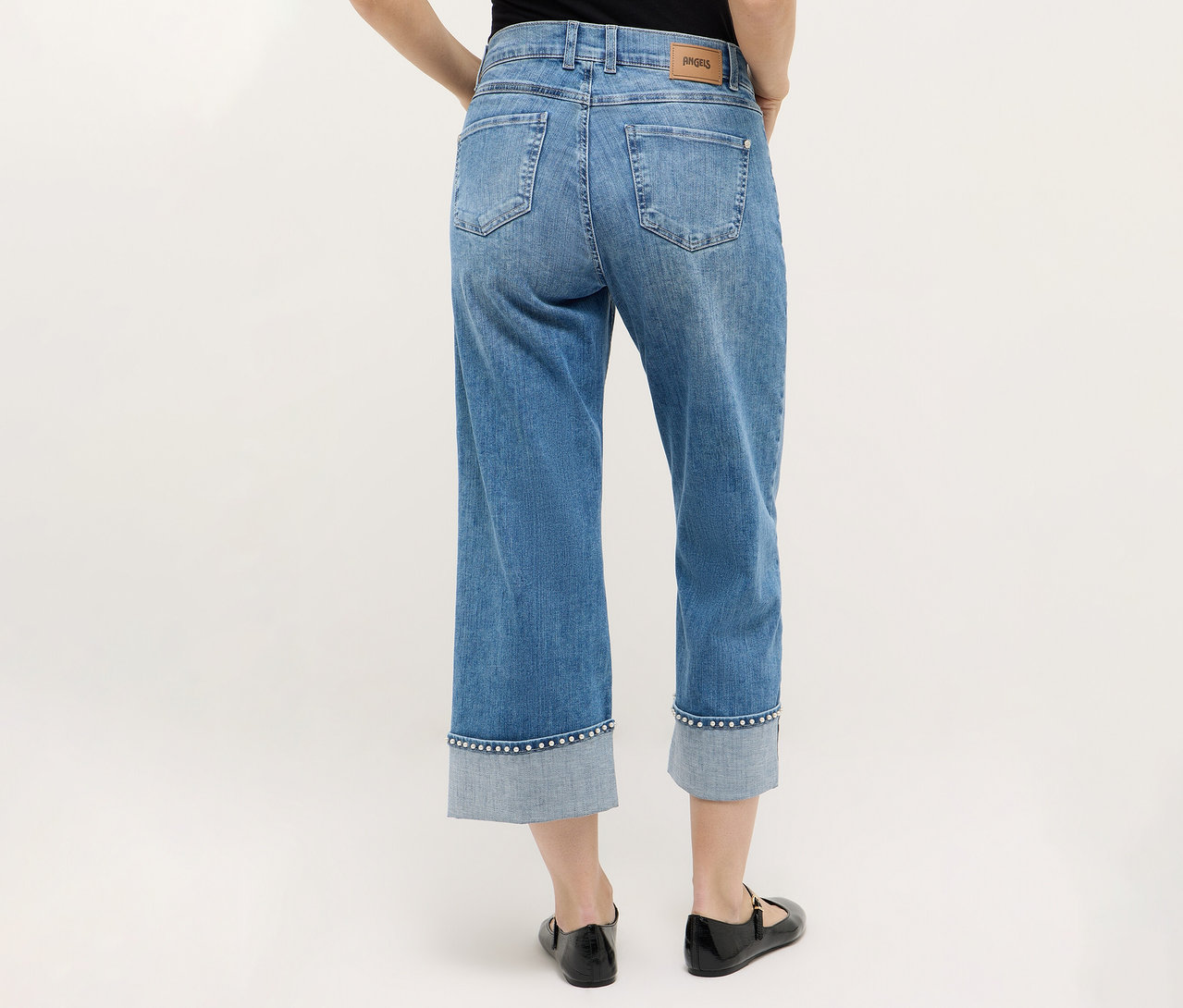 Person von hinten, die Angels Denim »Linn Cool« trägt, kombiniert mit schwarzen Schuhen vor einem neutralen Hintergrund.