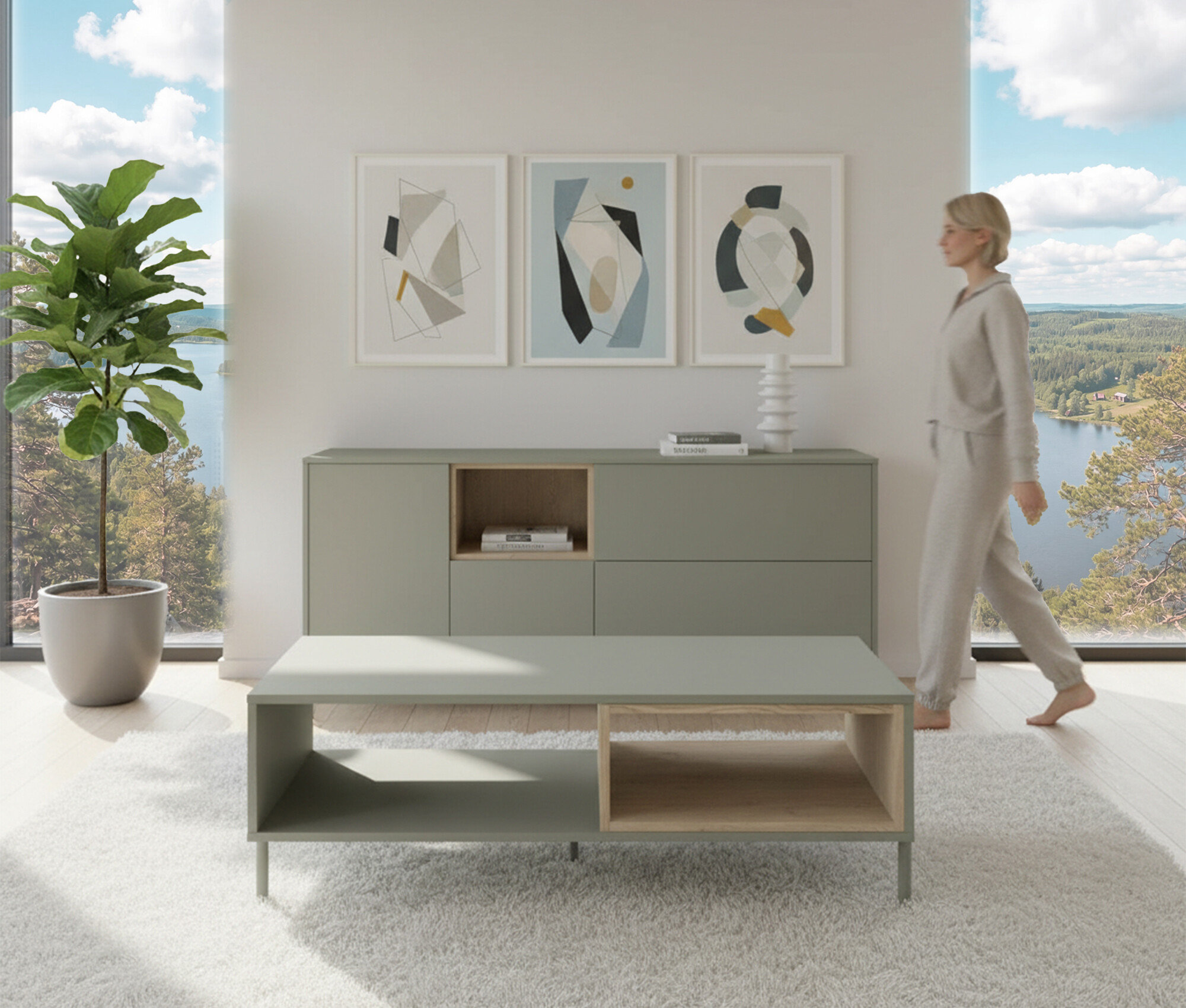 Frau geht an salbeigrünem Sideboard »Hygge« mit 1 Tür vorbei. Darüber hängen drei Bilder. Im Vordergrund steht ein Couchtisch.