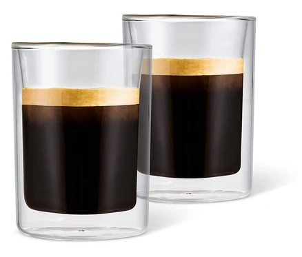 Zwei mit Kaffee gefüllte Caffè Crema Gläser mit Schaum vor einem weißen Hintergrund.