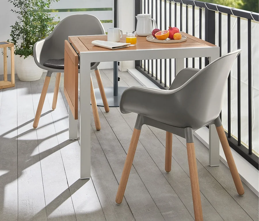Zwei graue Schalenstühle stehen an einem Ausklappbarer Tisch »Liska« auf einer Terrasse. Ein grauer Leco Balkon-Sonnenschirm spendet Schatten.
