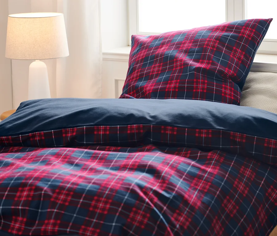 Auf einem Bett liegt Biber-Bettwäsche in Normalgröße und Biber-Bettwäsche in Normalgröße.