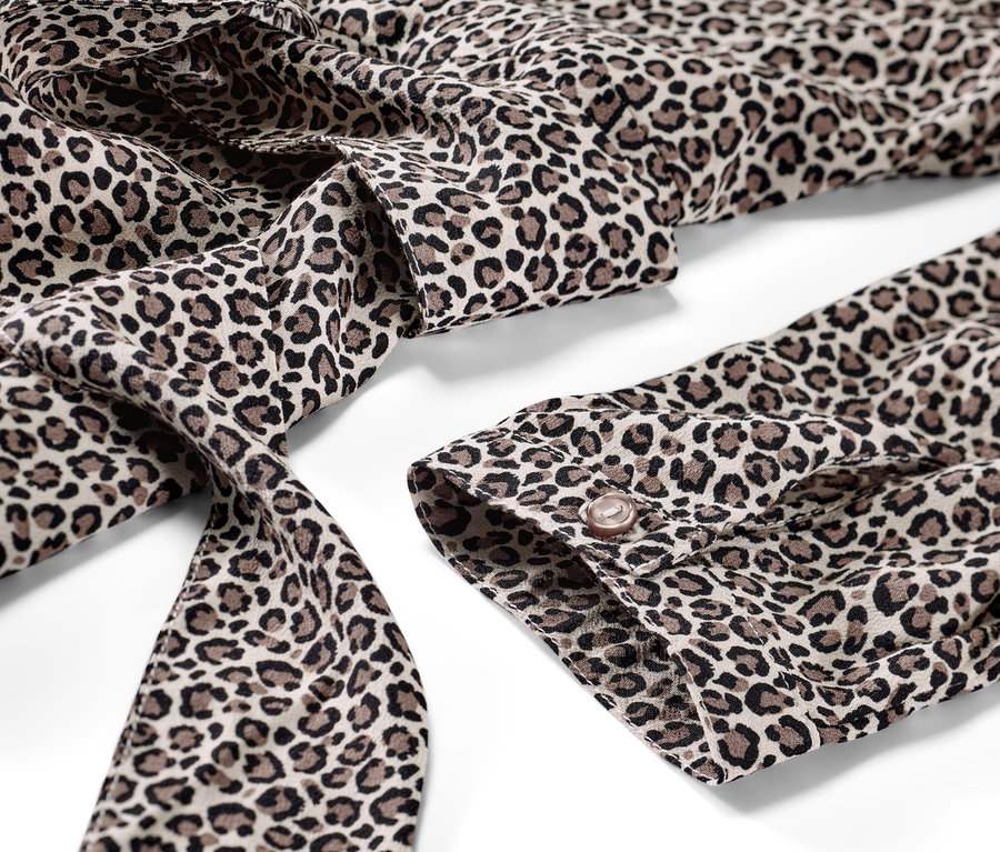 Detailansicht eines bedruckten Webkleids mit Leopardenmuster.