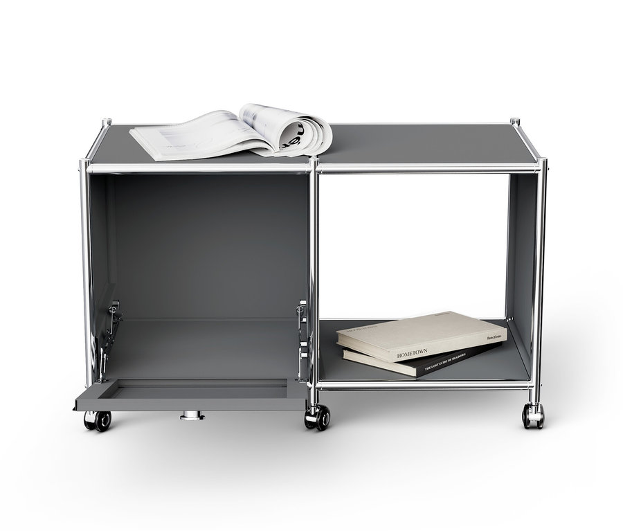 Ein grauer Beistelltisch Metall »CN3« mit einem offenen Klappfach, einem Buch und einer Zeitschrift.