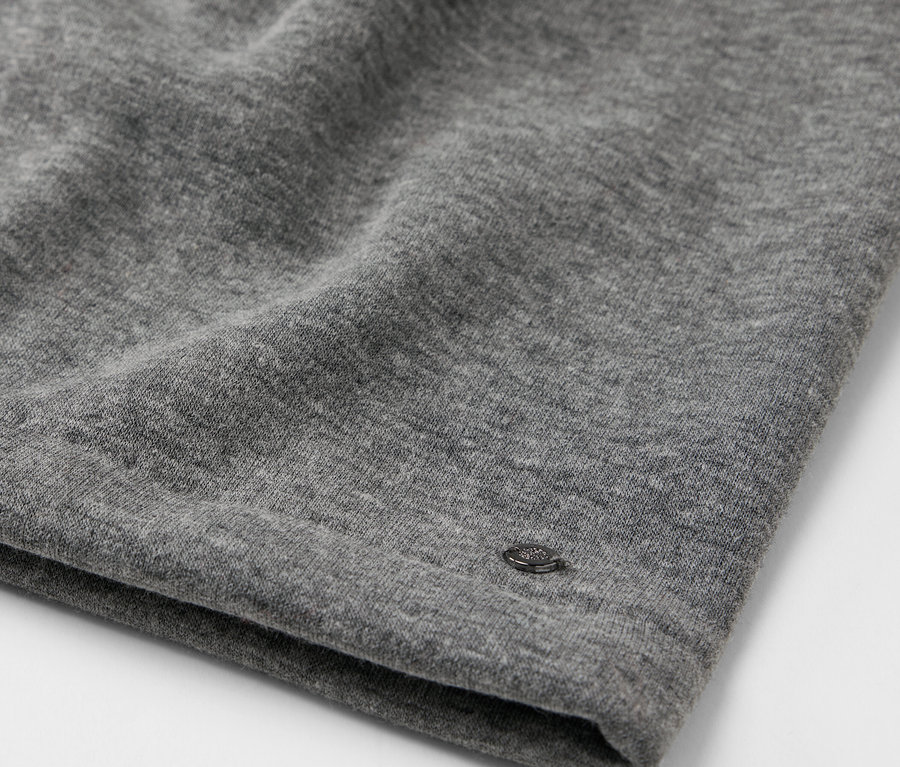 Detailaufnahme eines grauen Stoffes mit kleinem Logo.