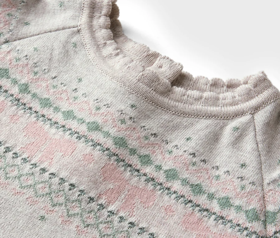 Detailansicht eines Pullovers mit rosa-grünem Muster und Rüschenausschnitt.