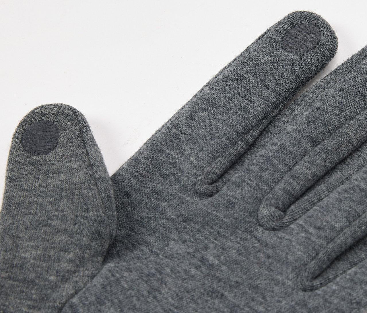 Detailaufnahme eines grauen Handschuhs mit Touchscreen-kompatibler Fingerspitze.