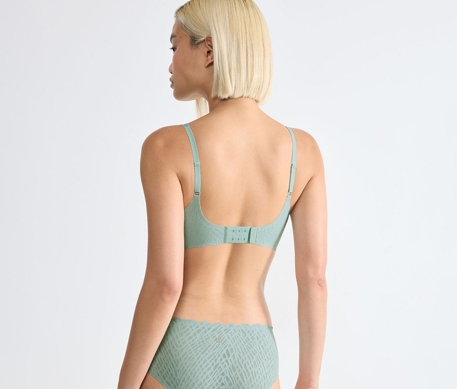 Rückansicht einer blonden Frau, die ein Unterwäscheset trägt: sloggi ZERO Feel Bliss Soft Bra, misty turquoise und dazu passende Slips.