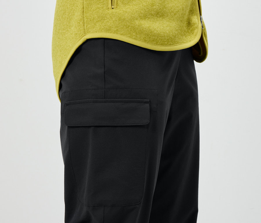 Schwarze Hose mit Tasche und gelbe Jacke.