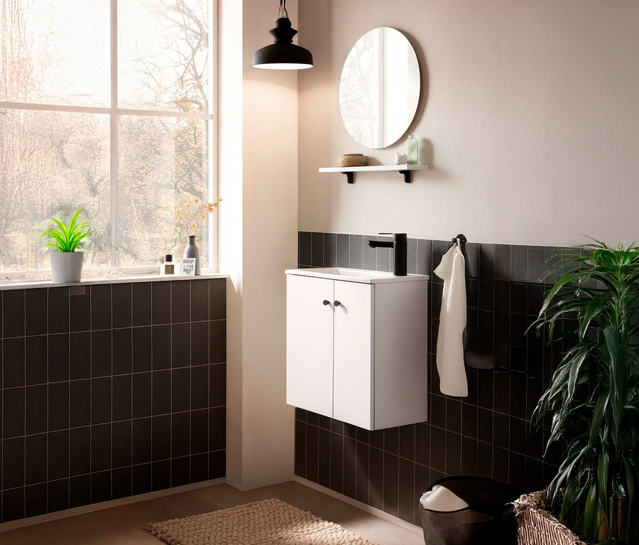 Ein Badezimmer mit einem runden WS Spiegel »Ebba« (45 cm) über einem Waschbeckenunterschrank.