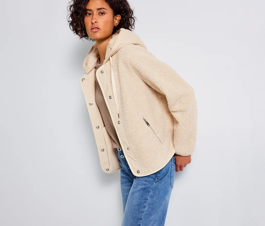 Frau trägt eine Street One Teddyjacke mit abnehmbarer Kapuze und Jeans.