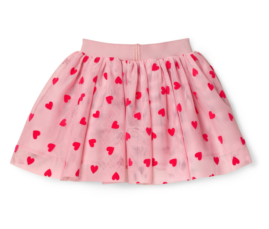 Ein rosa Tüllrock mit roten Herzen liegt auf einem weißen Hintergrund.