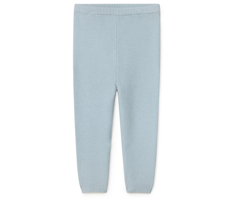 Hellblaue, gestrickte Hose für Babys liegt auf einem weißen Hintergrund.