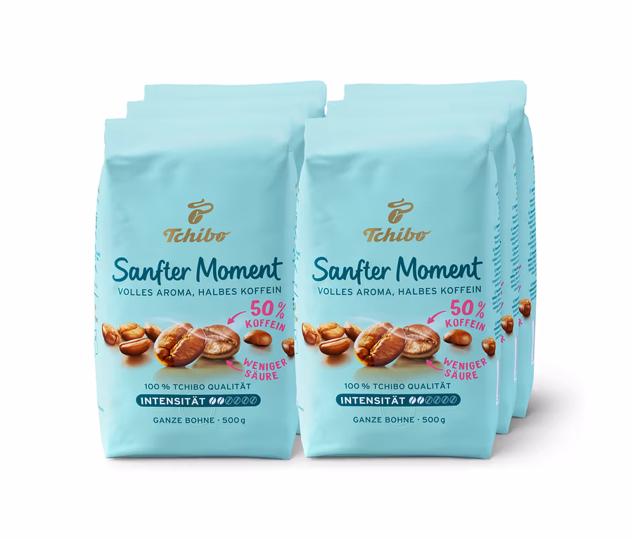 Mehrere Packungen Tchibo Sanfter Moment Kaffee mit 50% Koffein. Die Packungen sind hellblau und zeigen Kaffeebohnen.