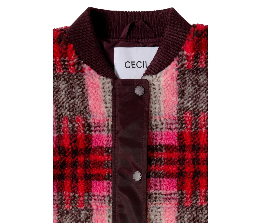 Nahaufnahme eines CECIL Blousons mit flauschiger Teddy-Textur und einem rot-rosa-braunen Karomuster. Er hat einen gerippten bordeauxroten Kragen und eine Knopfleiste mit zwei sichtbaren Druckknöpfen. Das weiße CECIL Markenetikett ist unter dem Kragen sichtbar.