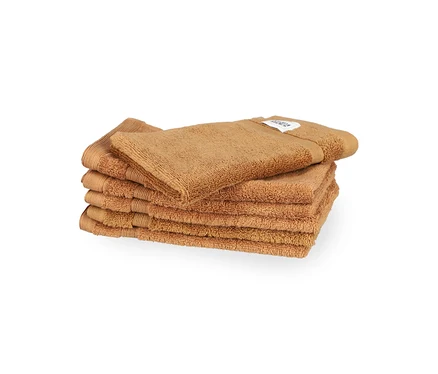 Ein Stapel von sechs braunen SCHÖNER WOHNEN-Kollektion "Cuddly" Gästehandtüchern, eines liegt obenauf.