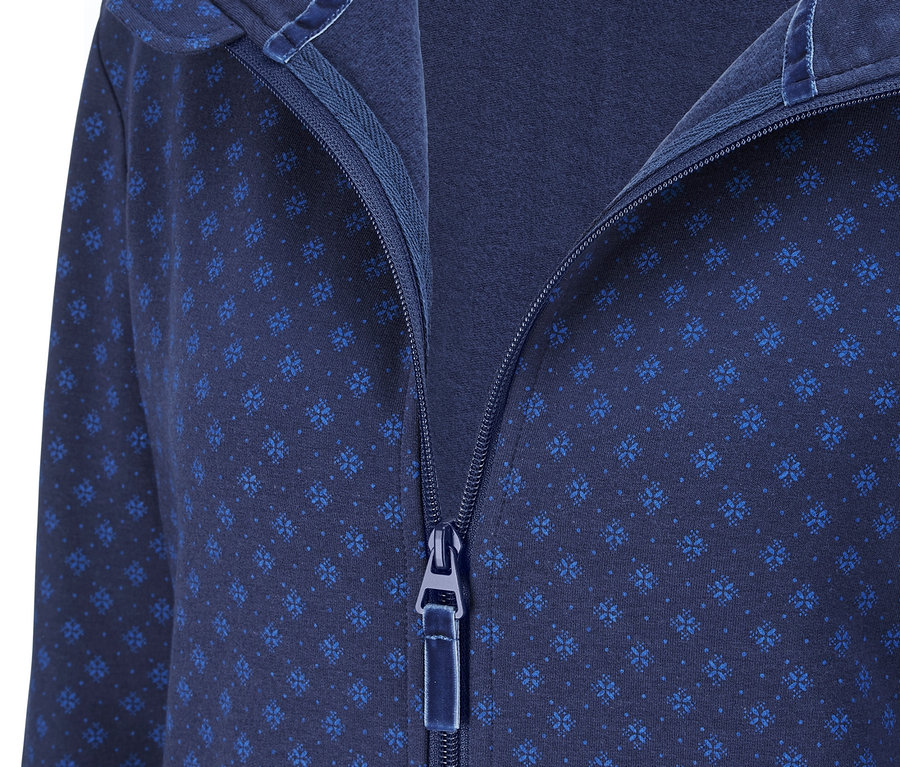 Detailansicht eines blauen Loungeoveralls mit Kapuze und Reißverschluss.