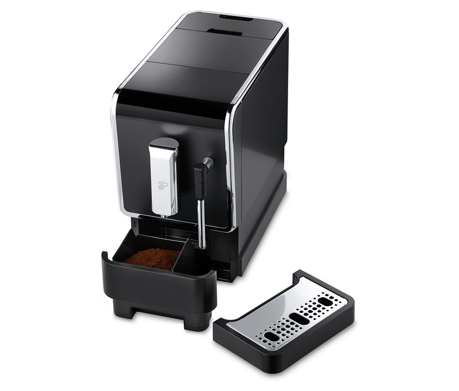 Detailansicht des anthrazitfarbenen Tchibo Kaffeevollautomaten »Esperto Latte« mit entnommenem Kaffeesatzbehälter und Tropfschale.
