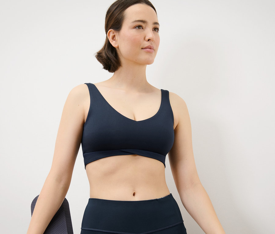 Frau trägt ein Marineblaues Sport-Bustier.