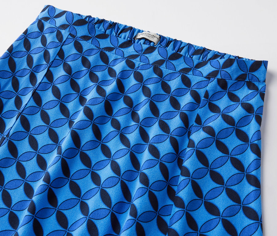 Detailansicht eines dunkelblauen, bedruckten Midirocks mit geometrischem Muster.