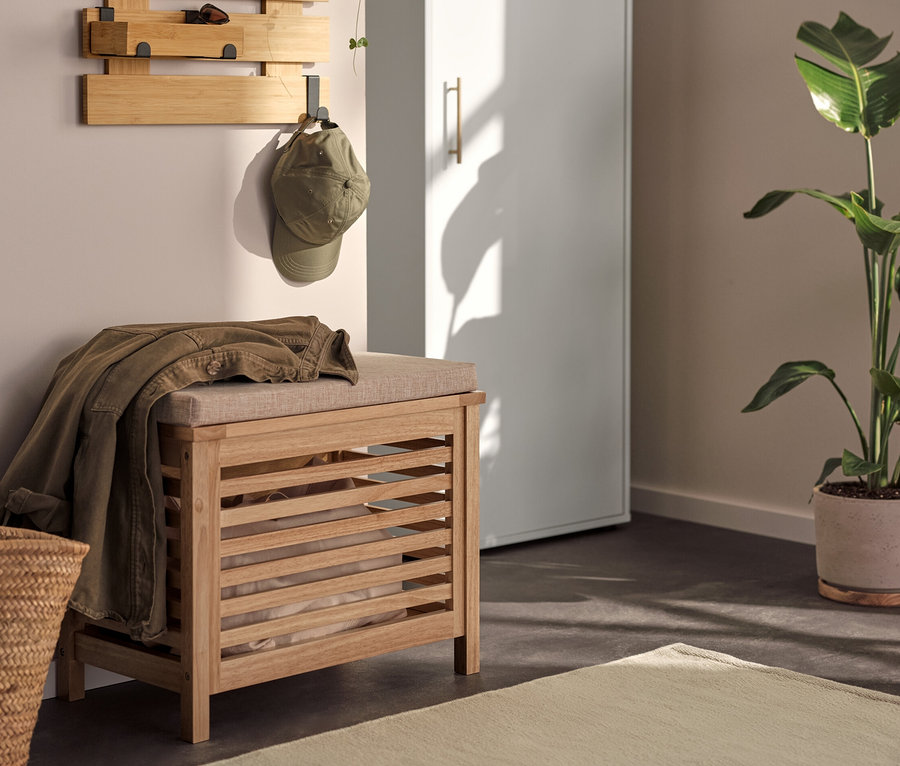 Einrichtung mit Universalschrank, Wandregal mit flexiblen Haken und Boden, und Massivholz-Sitztruhe mit Kissen.