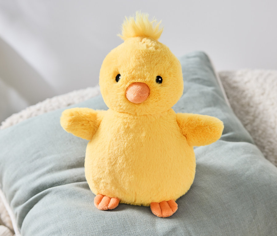 Ein Plüsch-Küken sitzt auf einem Kissen.