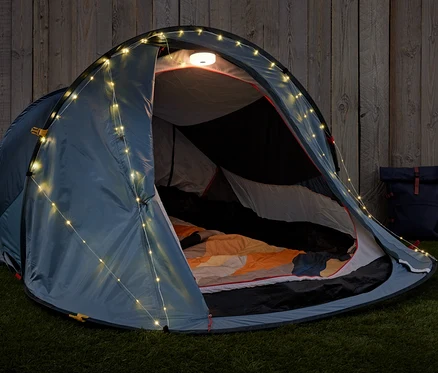 Geöffnetes Zelt mit 2-in-1-Camping-Lichterkette und Rucksack auf Gras.