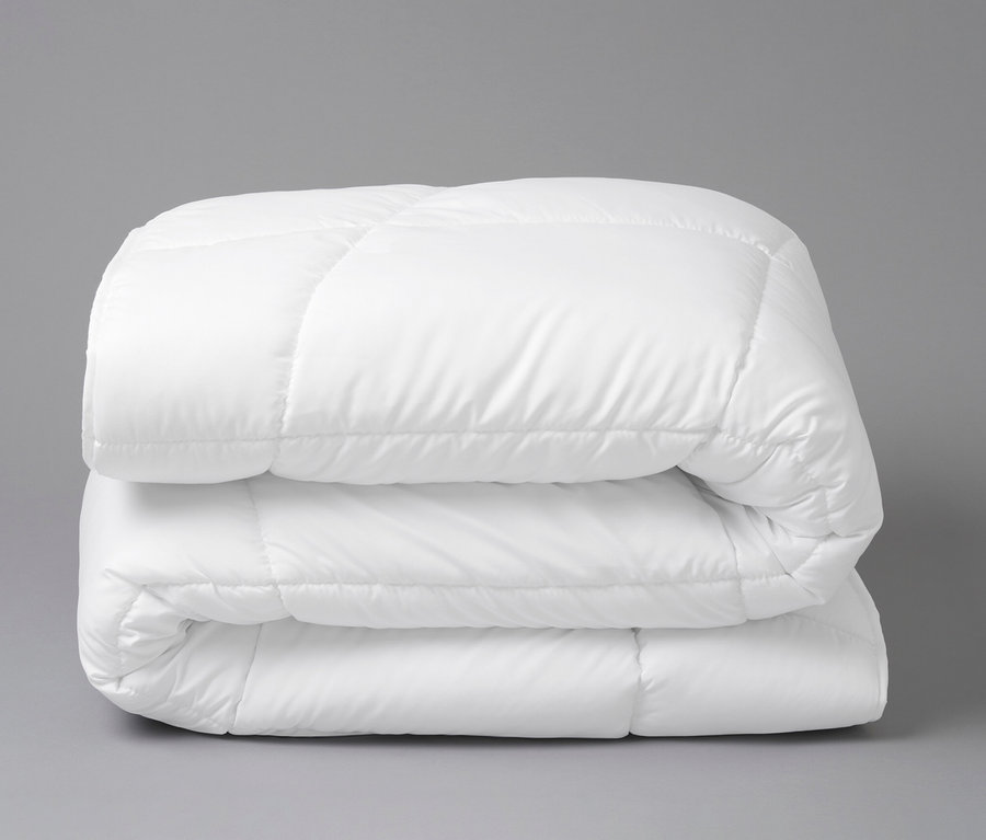 Gefaltete, weiße Home By TEMPUR® Luxe Duo-Decke auf grauem Hintergrund.