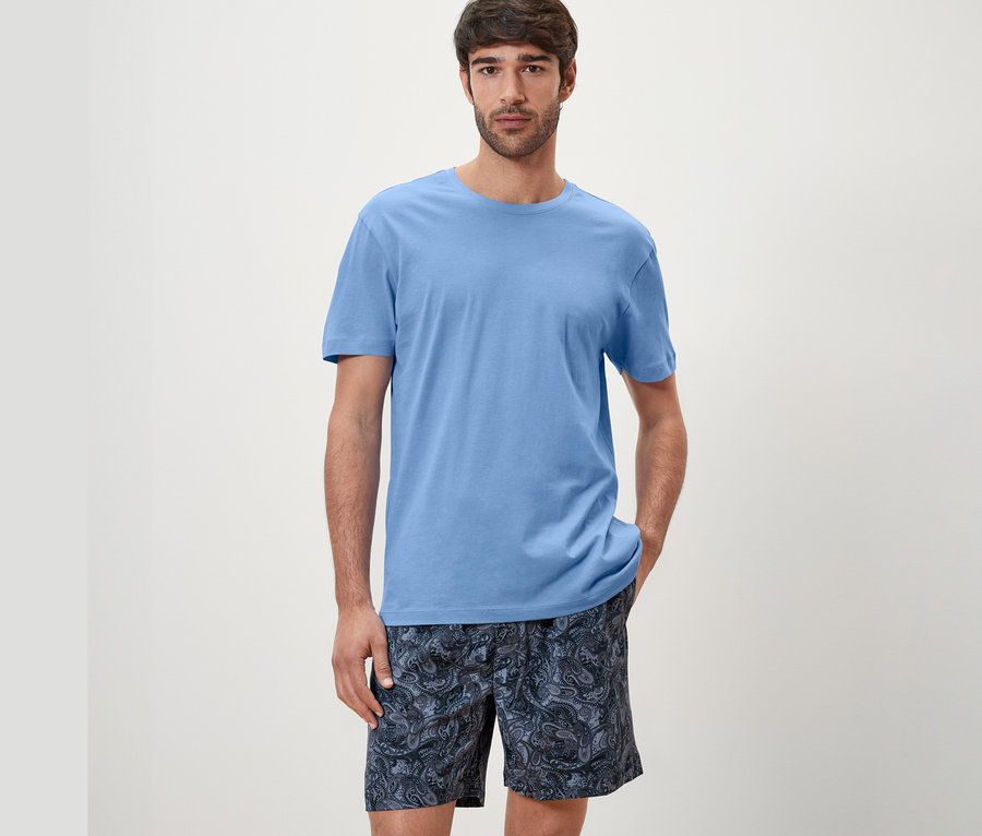 Mann trägt blaues Shorty-Pyjama-Set.