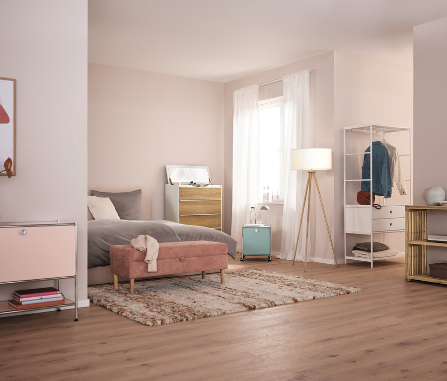 Schlafzimmer mit grauer LED-Akku-Tischleuchte auf Nachttisch.