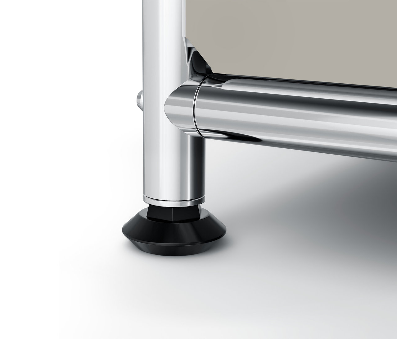 Detailaufnahme eines verchromten Möbelfußes mit schwarzem Sockel.