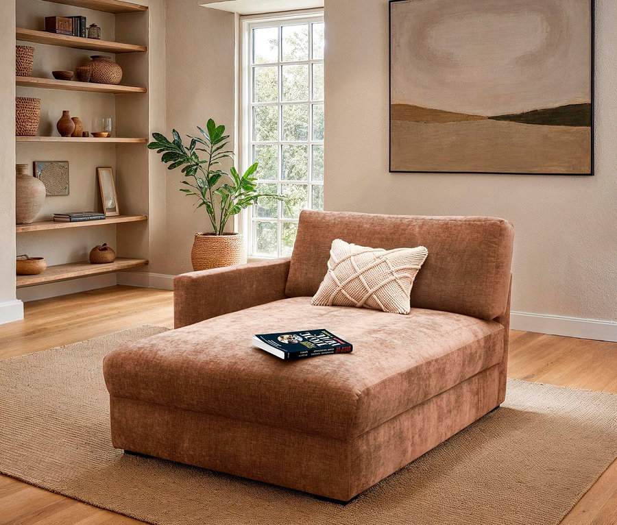 Braune Chaiselongue mit Kissen und Buch auf Teppich im Wohnzimmer.