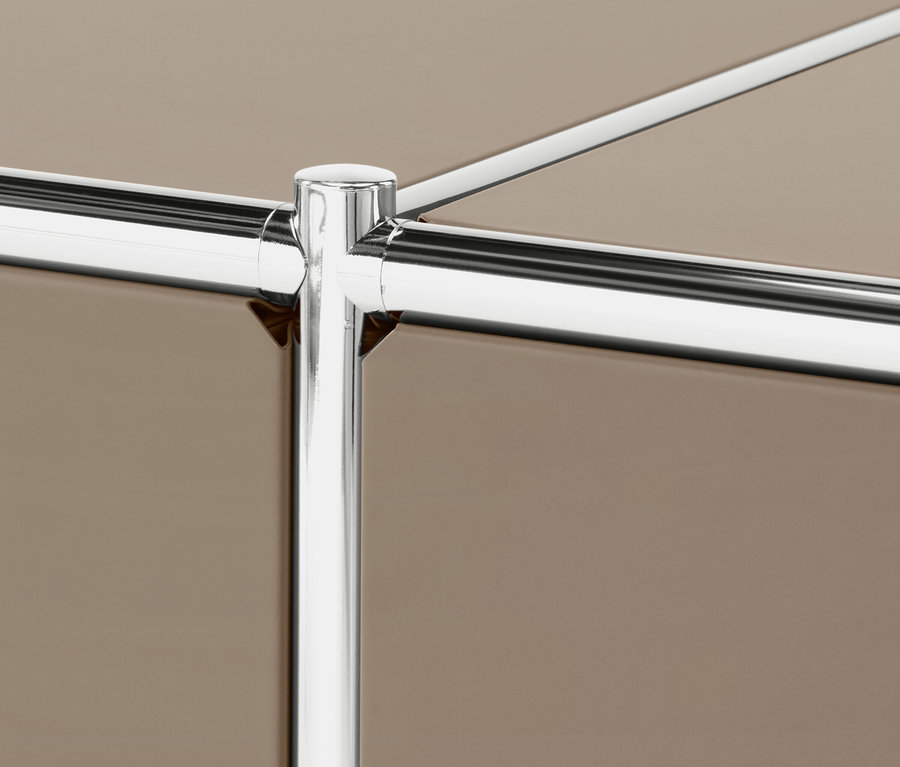 Detail einer Möbelecke mit verchromten Rohren und braunen Paneelen.