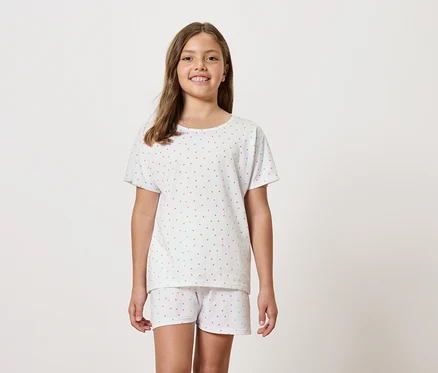 Mädchen trägt weißen kurzärmeligen Schlafanzug mit Shorts.