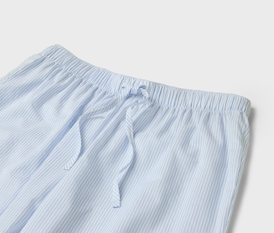 Detailansicht einer hellblau-weiß gestreiften Pyjamahose mit Kordelzug.