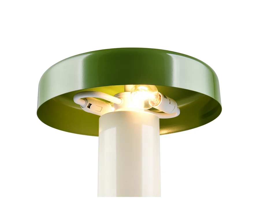 Nahaufnahme einer Lampe mit grünem, pilzförmigem Schirm und cremefarbenem zylindrischem Sockel, darunter eine leuchtende Glühbirne.