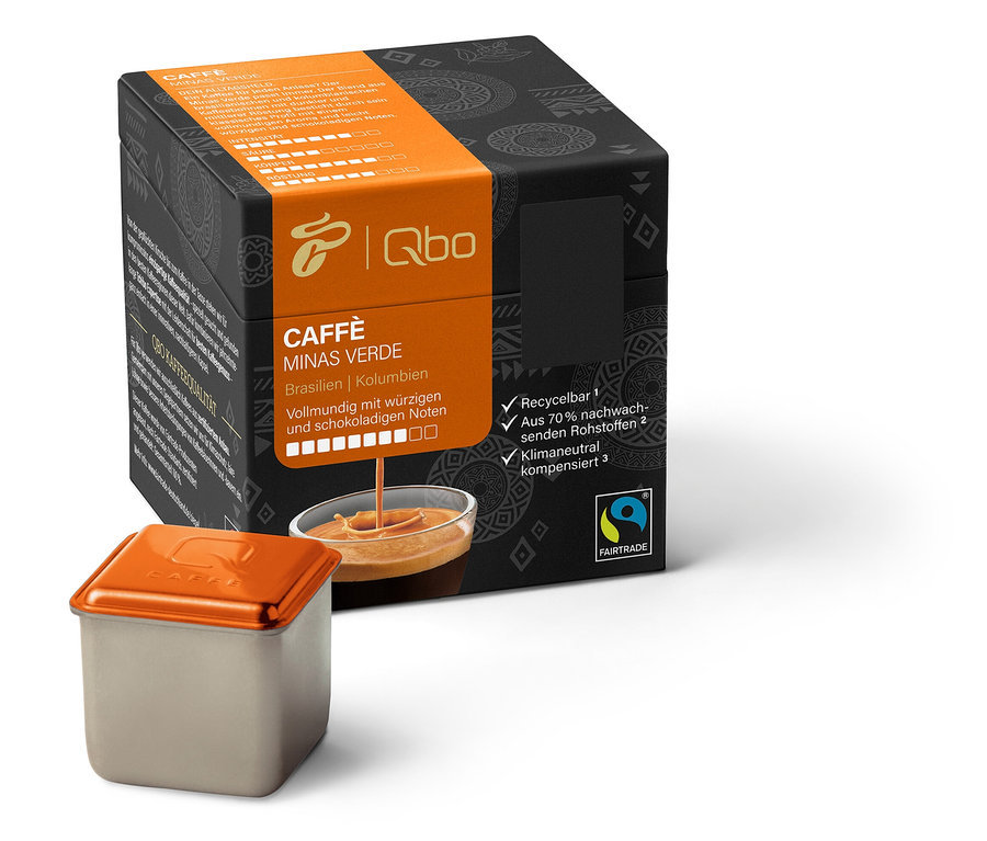 Eine Packung Qbo Caffè MINAS VERDE und eine Kapsel. Die Packung ist schwarz mit einem orangefarbenen Streifen. Die Kapsel ist silberfarben mit einem orangefarbenen Deckel.